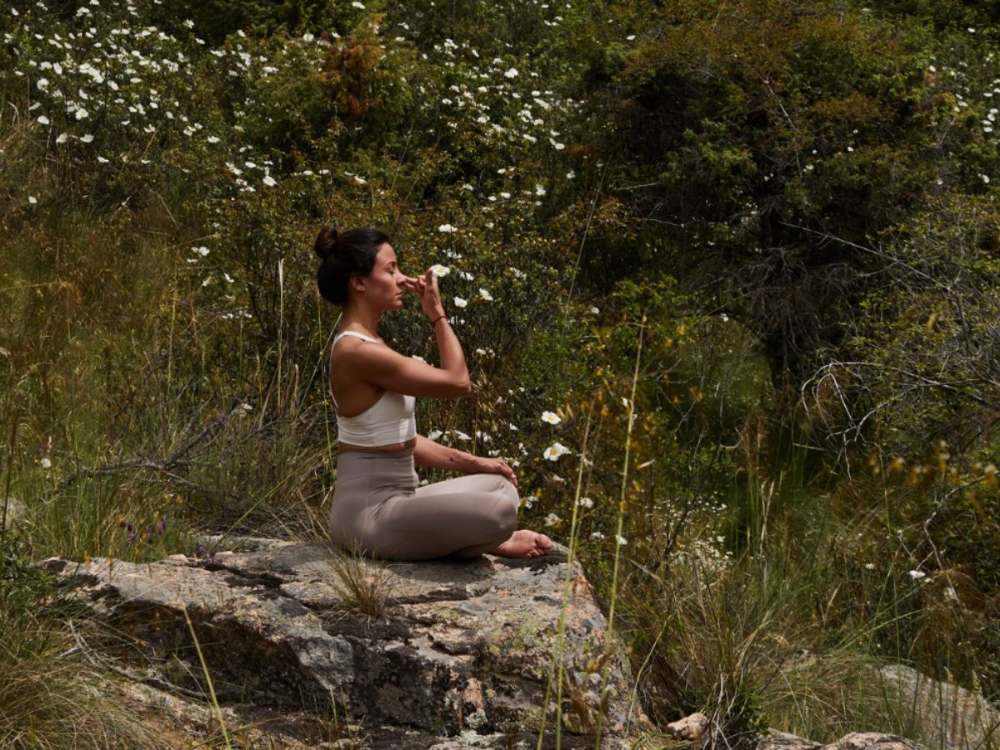 Exercice de respiration assis sur un rocher, dans la garrigue