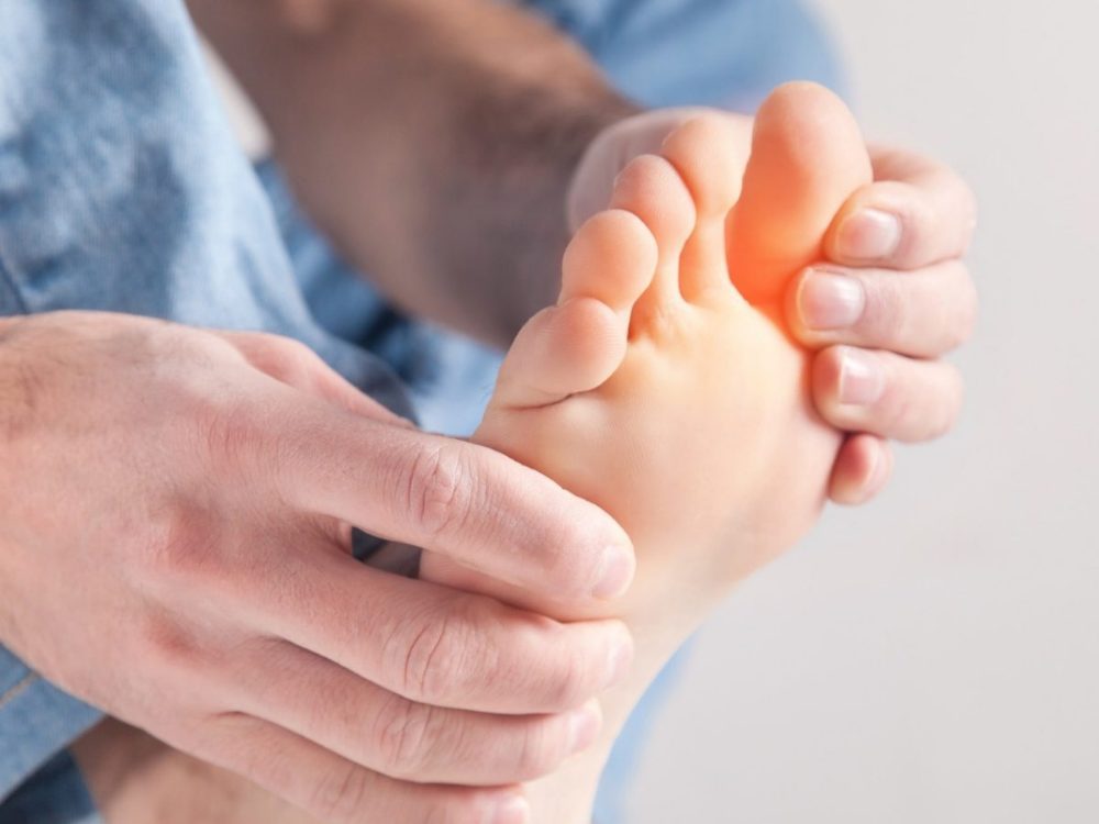 Mains massant la plante du pied, avant-pied douloureux