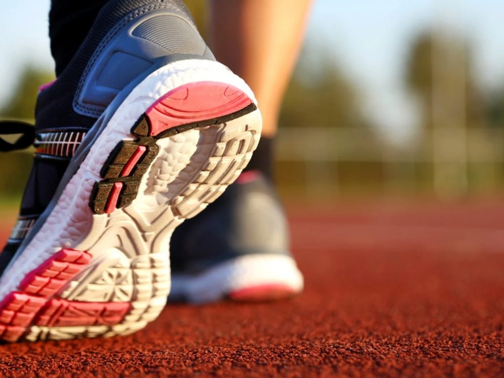 Semelle d'une chaussure de course en appui sur une piste d'athlétisme