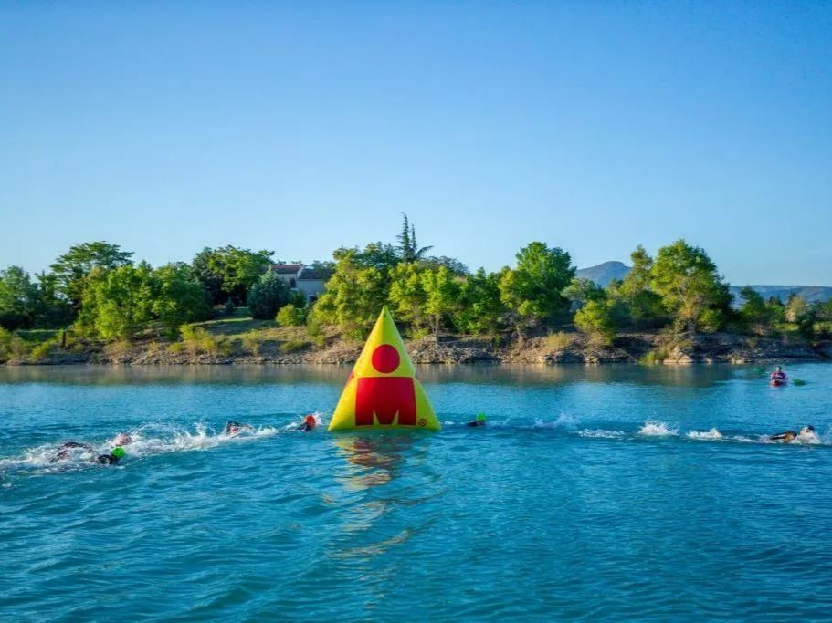 Nageurs autour d'une bouée de parcours au départ d'un Ironman